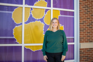 third grade teacher Melissa Kyser stands in front of a brick wall